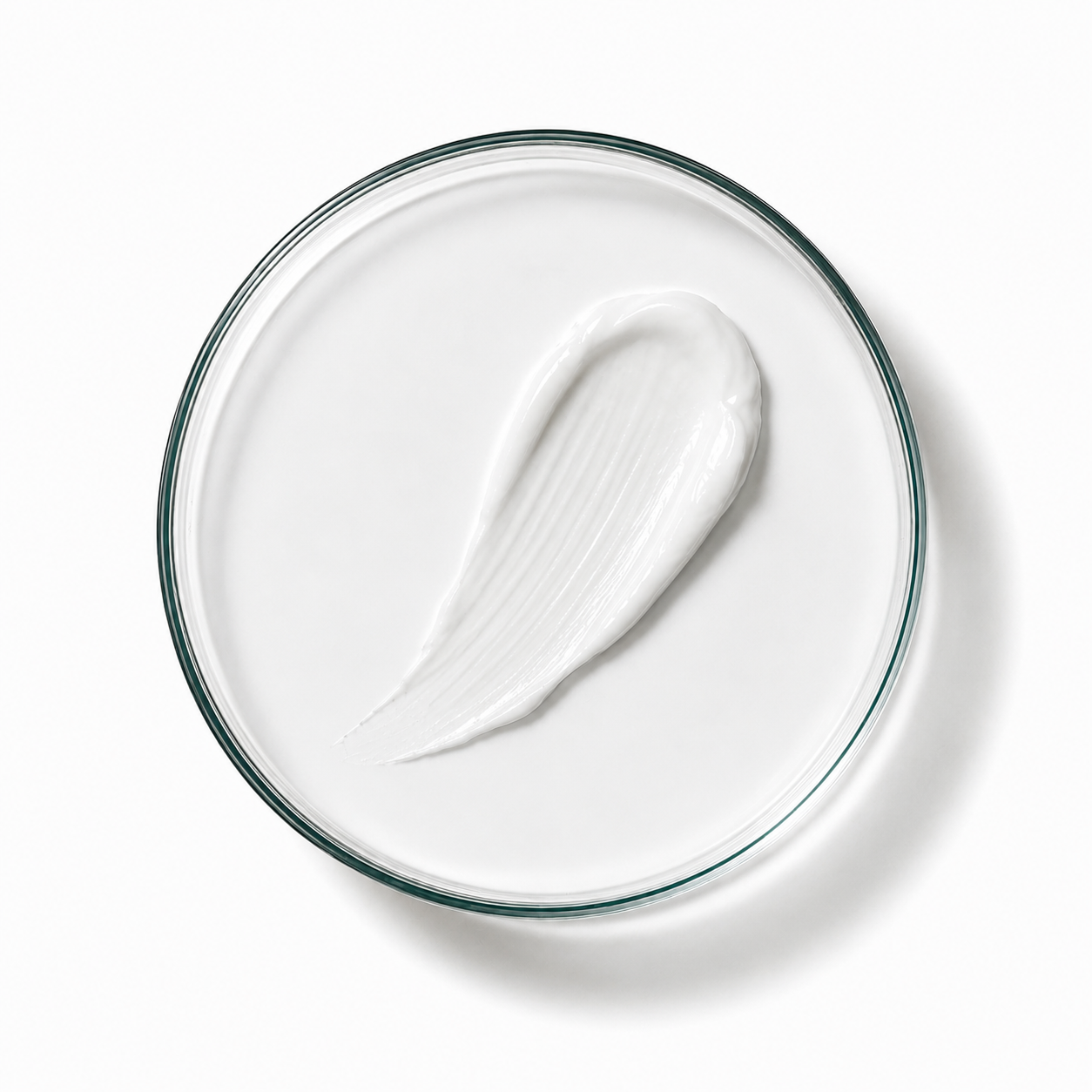 White cream on a clear glass plate with a white background