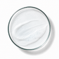 Glass bowl filled with a white creamy substance on a white background