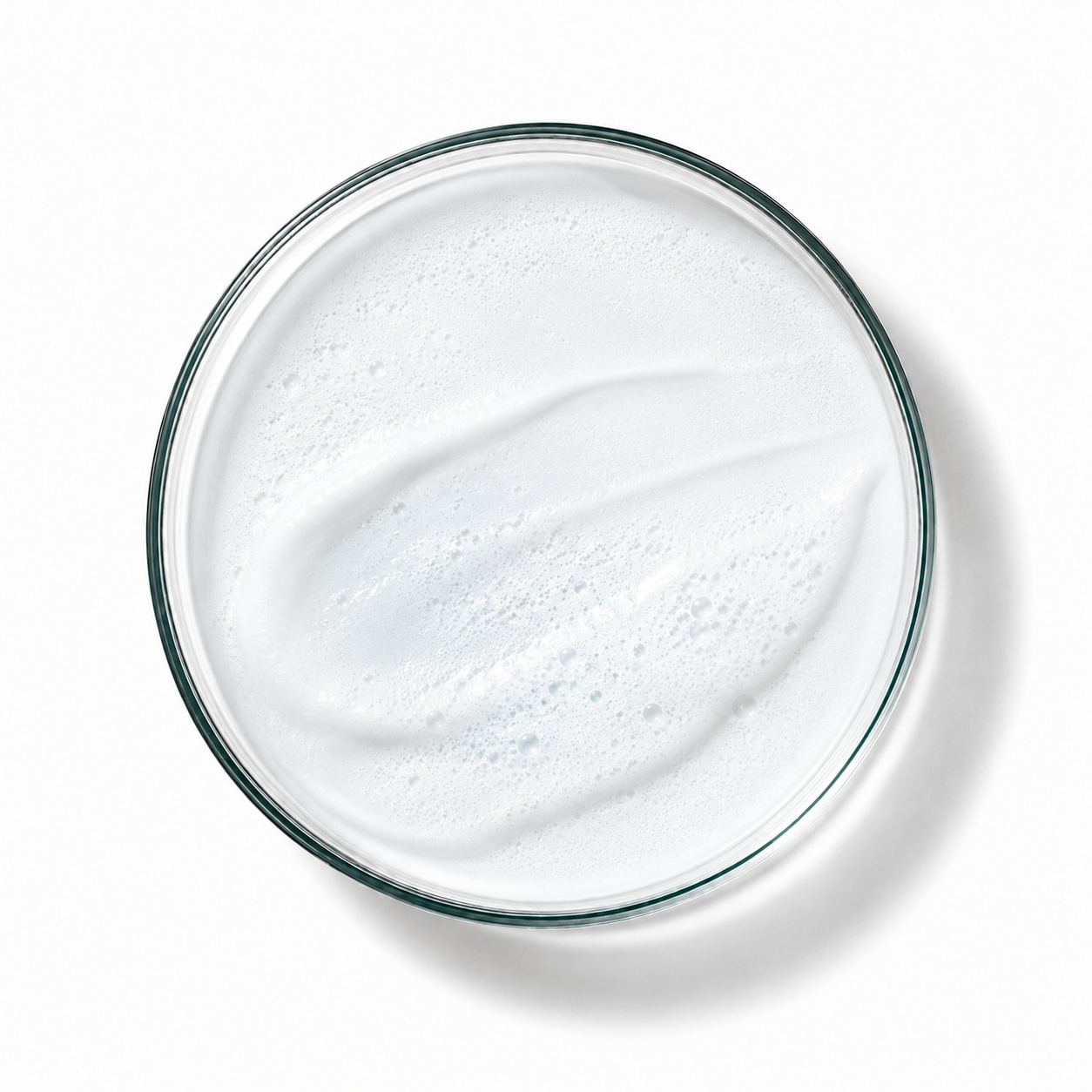 Glass bowl filled with a white creamy substance on a white background